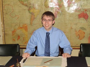 2014 Churchill Scholar Josh Shutter sitting at Winston Churchill's war room desk.